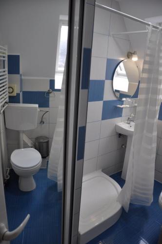 a blue and white bathroom with a toilet and a sink at MANEA Orsova in Orşova