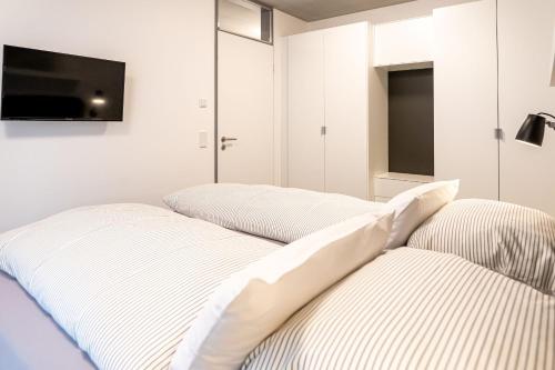 two beds in a bedroom with a tv on the wall at Refugium am Wasserturm in Emsdetten
