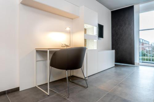 a black chair sitting at a desk in a room at Refugium am Wasserturm in Emsdetten