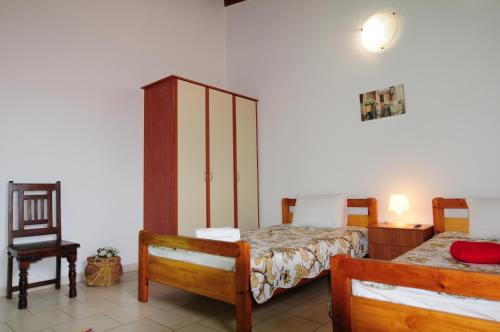 a bedroom with two beds and a chair at Orizontes Suites XL in Kalamos