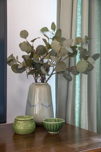 a vase with a plant in it sitting on a table at Seven cafe & hotel in Pogradec