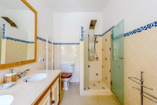 un bagno con due lavandini, una doccia e un WC di Endless Summer Luxury Villa a Quinta do Lago