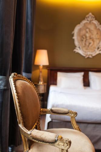 a chair in a hotel room with a bed at Hotel Diamonds and Pearls in Antwerp