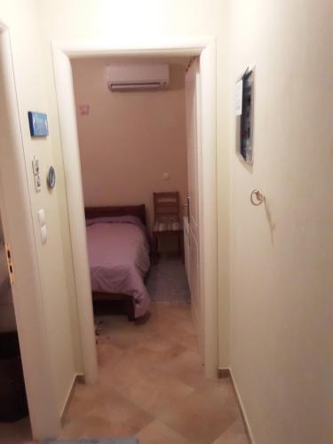 um corredor com uma cama num pequeno quarto em Leonidio Rock climbing house em Leonidio