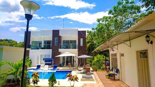 a house with a swimming pool in front of a house at Casa Quinta Santana in Melgar