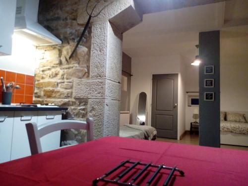 Le Gîte du haut في Châtillon-la-Palud: مطبخ وغرفة معيشة مع طاولة حمراء