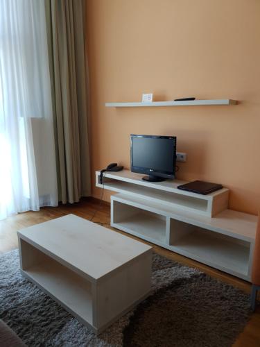 a living room with a tv and a table at Apartmán 401 - Hotel s apartmánmi CROCUS . in Štrbské Pleso