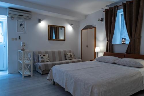 a bedroom with a bed and a couch at Studio Banovac in Dubrovnik