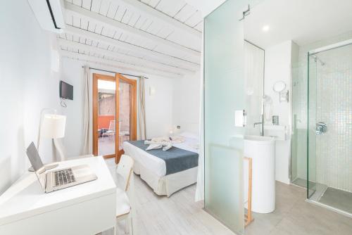 a white room with a bed and a bathroom at Alcudia Petit - Turismo de Interior in Alcudia