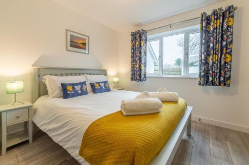 a bedroom with a bed with a yellow blanket on it at Beacon View in St. Agnes 