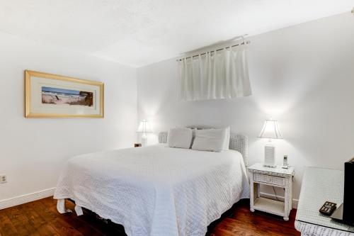 サンタ・ローザ・ビーチにあるEmerald Hillの白いベッドルーム(ベッド1台、テレビ付)