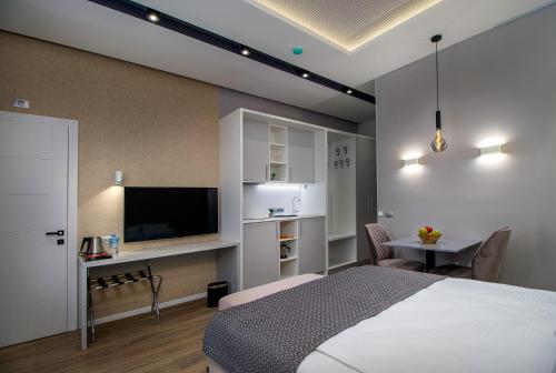 Schlafzimmer mit einem Bett, einem TV und einem Tisch in der Unterkunft Beys Palace apartments Sarajevo in Sarajevo