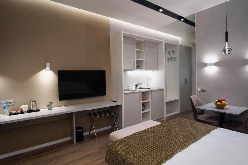 Zimmer mit einem Bett und einem Schreibtisch mit einem TV in der Unterkunft Beys Palace apartments Sarajevo in Sarajevo