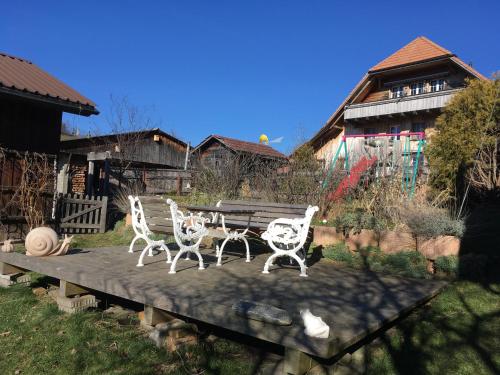 a statue of three chairs and a table in a yard at 3,5 Zimmerferienwohnung Schwalbenäscht Rüeggisberg in Rüeggisberg