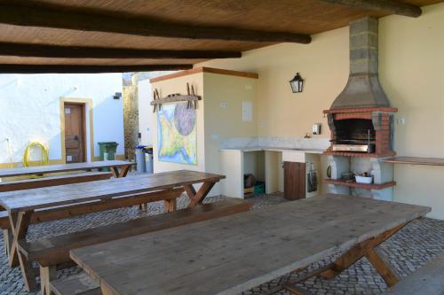 a large room with wooden tables and an oven at Quinta do Tio Viagem in Quinta do Anjo