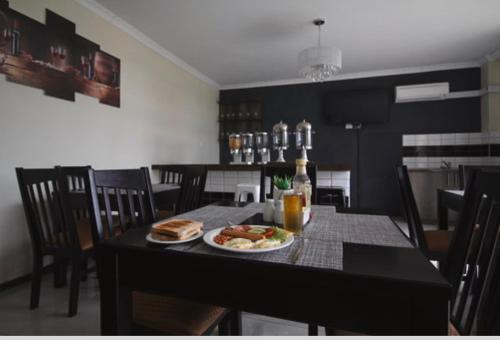 a table with a plate of food and a bottle of beer at Scenery Guest House in Kokstad