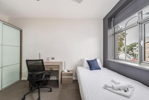 a bedroom with a bed and a desk and a computer at Alloggio Studios on King in Newcastle