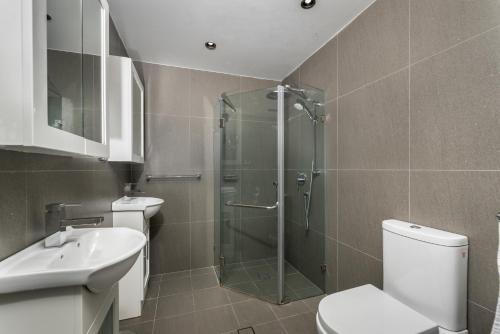 a bathroom with a shower and a toilet and a sink at Alloggio Studios on King in Newcastle