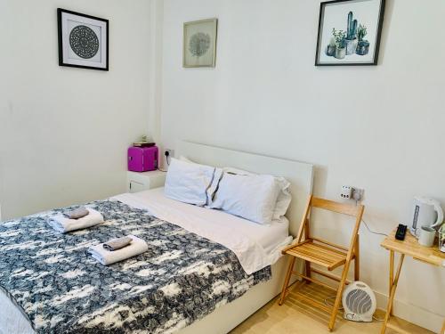 1 dormitorio con 1 cama con toallas en Quiet cosy rooms en Harrow