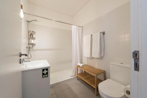 a white bathroom with a toilet and a sink at Light Blue Apartment in Porto