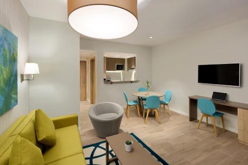 a living room with a couch and a table and chairs at Adagio Jeddah City Center in Jeddah