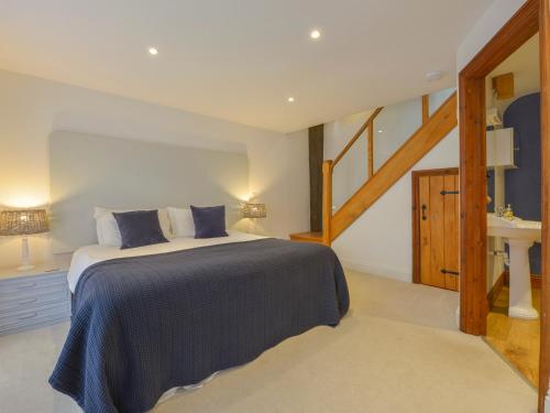 a bedroom with a large bed and a staircase at Mixit Cottage in Kingsbridge