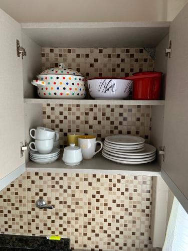 a cupboard with plates and cups and dishes in it at Estudio Mar in Mar del Plata