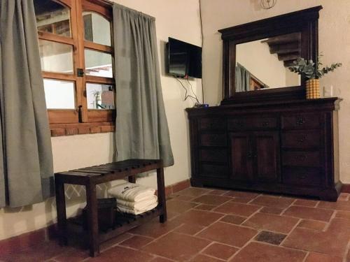 a bathroom with a wooden dresser and a mirror at Hotel Del Rio in Huasca de Ocampo