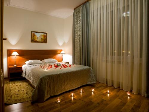 ein Schlafzimmer mit einem Bett mit Kerzen auf dem Boden in der Unterkunft Hotel Re Vita in Truskawez