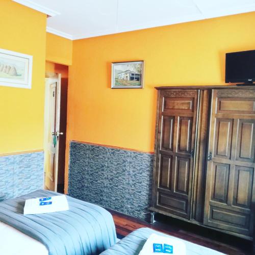 a room with a bed and a wooden cabinet at Txoko Maitea Pentsioa in Urnieta