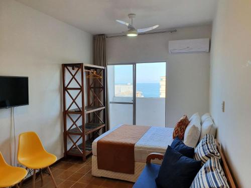 1 dormitorio con 1 cama y 1 habitación con TV en Flats Boulevard Center Pitangueiras en Guarujá