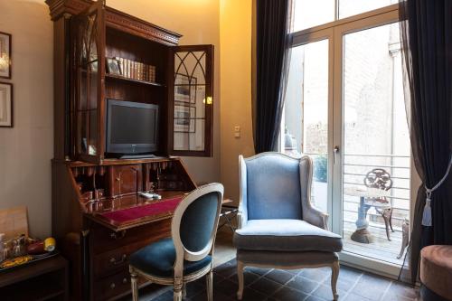 a room with a desk and two chairs and a television at Hotel Diamonds and Pearls in Antwerp