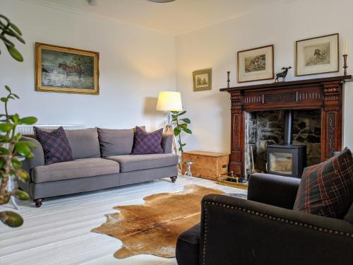 a living room with a couch and a fireplace at Central Hawick spacious stylish flat with log burner in Hawick