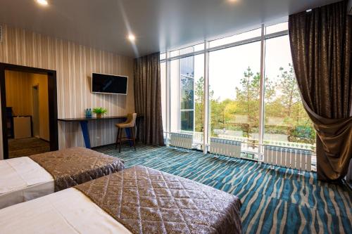 una camera d'albergo con due letti e una grande finestra di Hotel Druzhba a Blagoveščensk