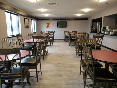 a dining room filled with tables and chairs at Super 8 by Wyndham Milwaukee Airport in Milwaukee