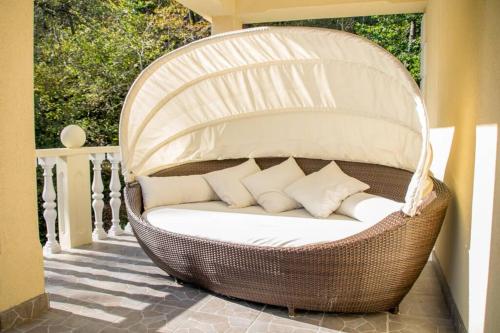 a wicker chair with pillows on a porch at Kuća za odmor „VILLA MARIJA” in Kostel