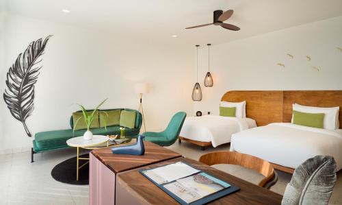 um quarto de hotel com duas camas e uma mesa em The Aviary Hotel em Siem Reap