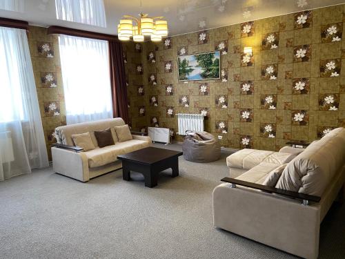 a living room with two couches and a wall with flowers at Hotel Druzhba in Blagoveshchensk