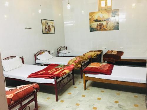 a room with four beds and a row of chairs at Hotel Tokyo Palace in Jaisalmer