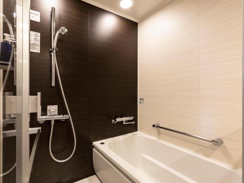 a bathroom with a bath tub and a shower at Solaria Nishitetsu Hotel Kagoshima in Kagoshima