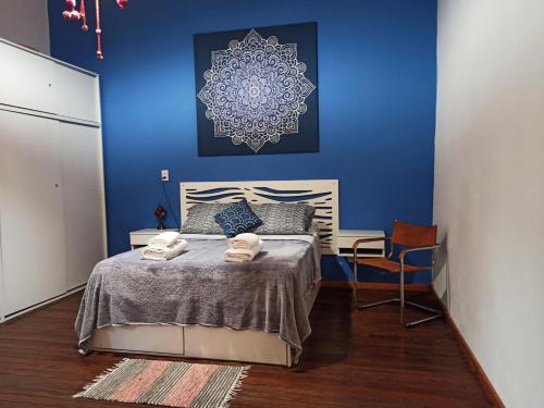1 dormitorio con 1 cama con pared azul en BELLA CASA 110m2 - CENTRO - PATIO - PARRILLA en Rosario