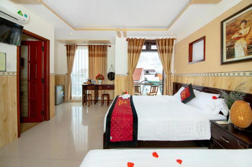a bedroom with two beds and a dining room at Homestay May Trang in Hoi An