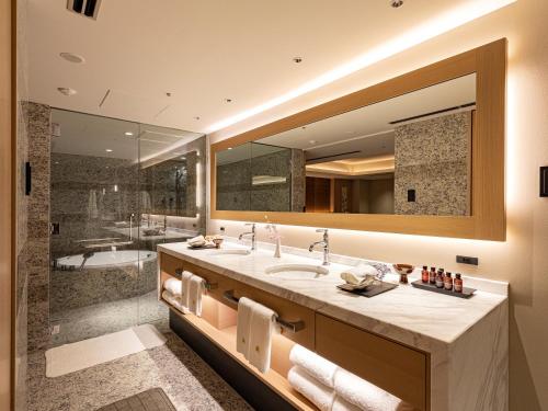 a bathroom with a large mirror and a tub at Hotel Nikko Fukuoka in Fukuoka
