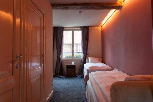 a bedroom with two beds and a window at Hotel Diamonds and Pearls in Antwerp