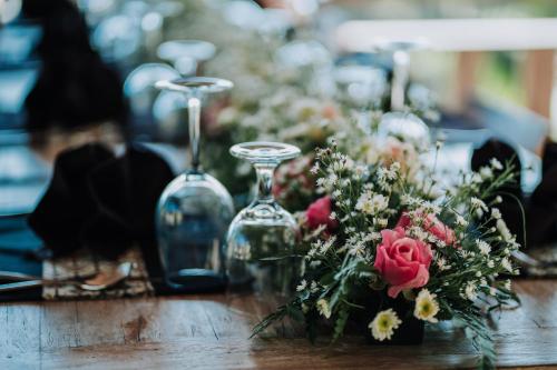 - une table avec un bouquet de fleurs et des verres à vin dans l'établissement Pondok Sebatu Villa, à Tegalalang