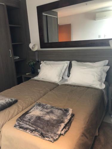 1 Schlafzimmer mit 2 Betten und einem Wandspiegel in der Unterkunft Flat 507 próximo ao Projac Jacarepaguá in Rio de Janeiro