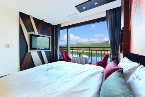 a bedroom with a bed and a large window at Moonlight Blue Pension in Gapyeong