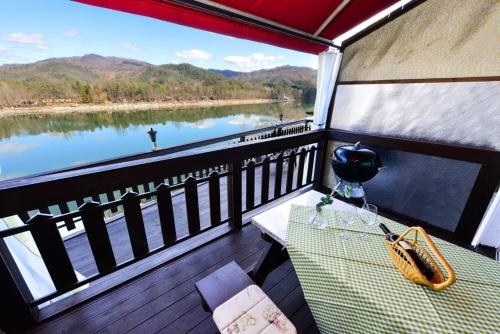 a balcony with a table and a view of a river at Moonlight Blue Pension in Gapyeong