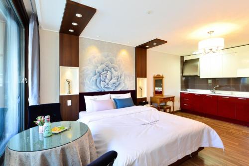 a hotel room with a large bed and a table at Moonlight Blue Pension in Gapyeong