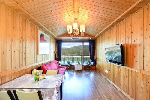 a room with a table and a couch and a television at Moonlight Blue Pension in Gapyeong